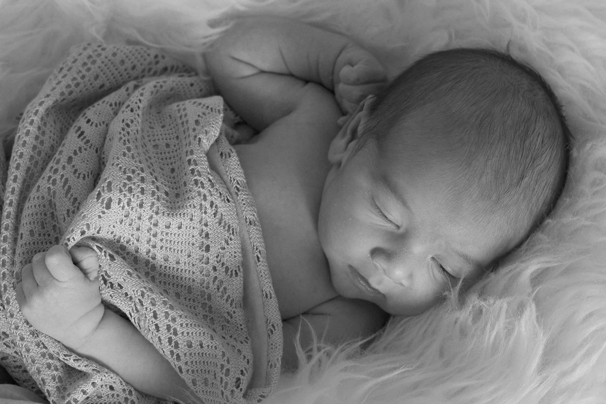 Sleeping infant boy with swaddle blanket
