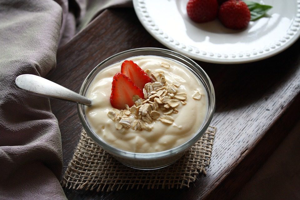 Bowl of greek yogurt with strawberries and whole grain oats