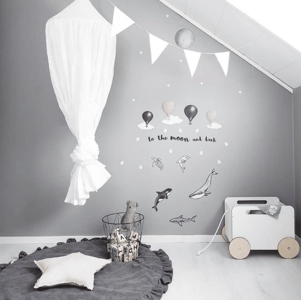 Creme cot canopy in play corner with toys wall stickers and star cushion