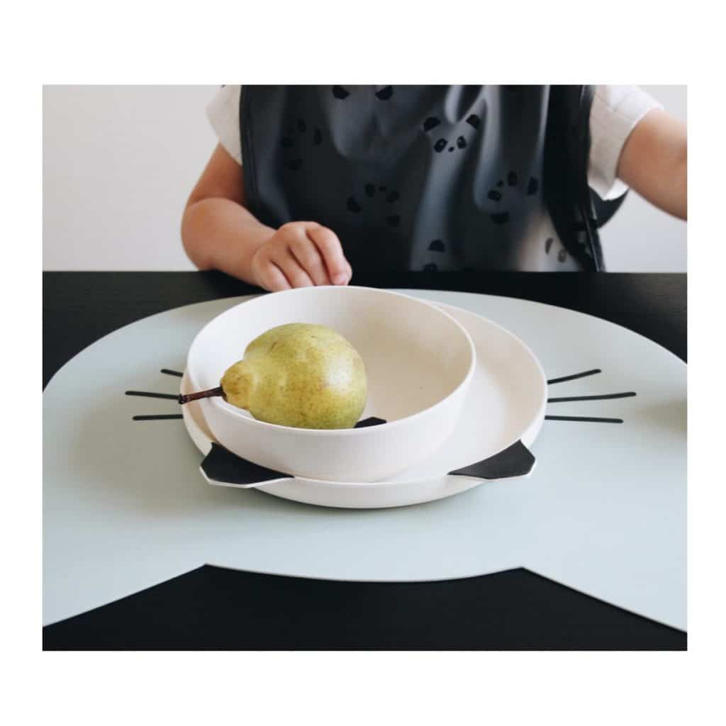 Bamboo plate set with a panda face and a pear in it