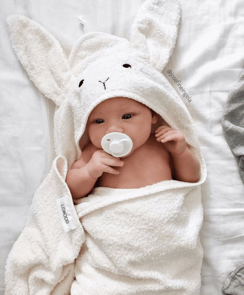 Infant in rabbit hooded baby towel