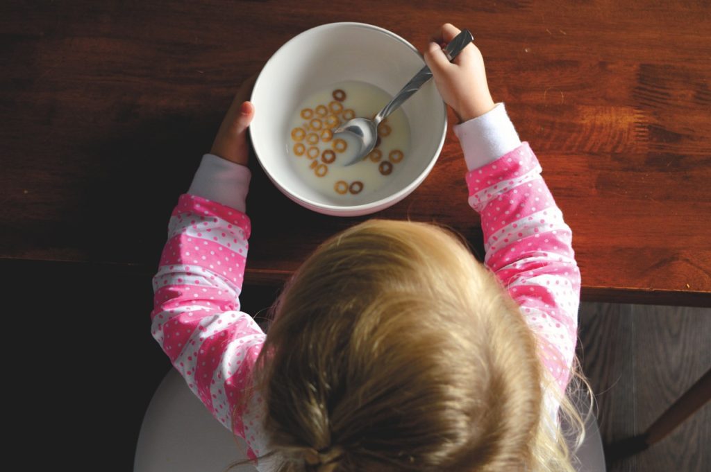 Child eating cereal at table